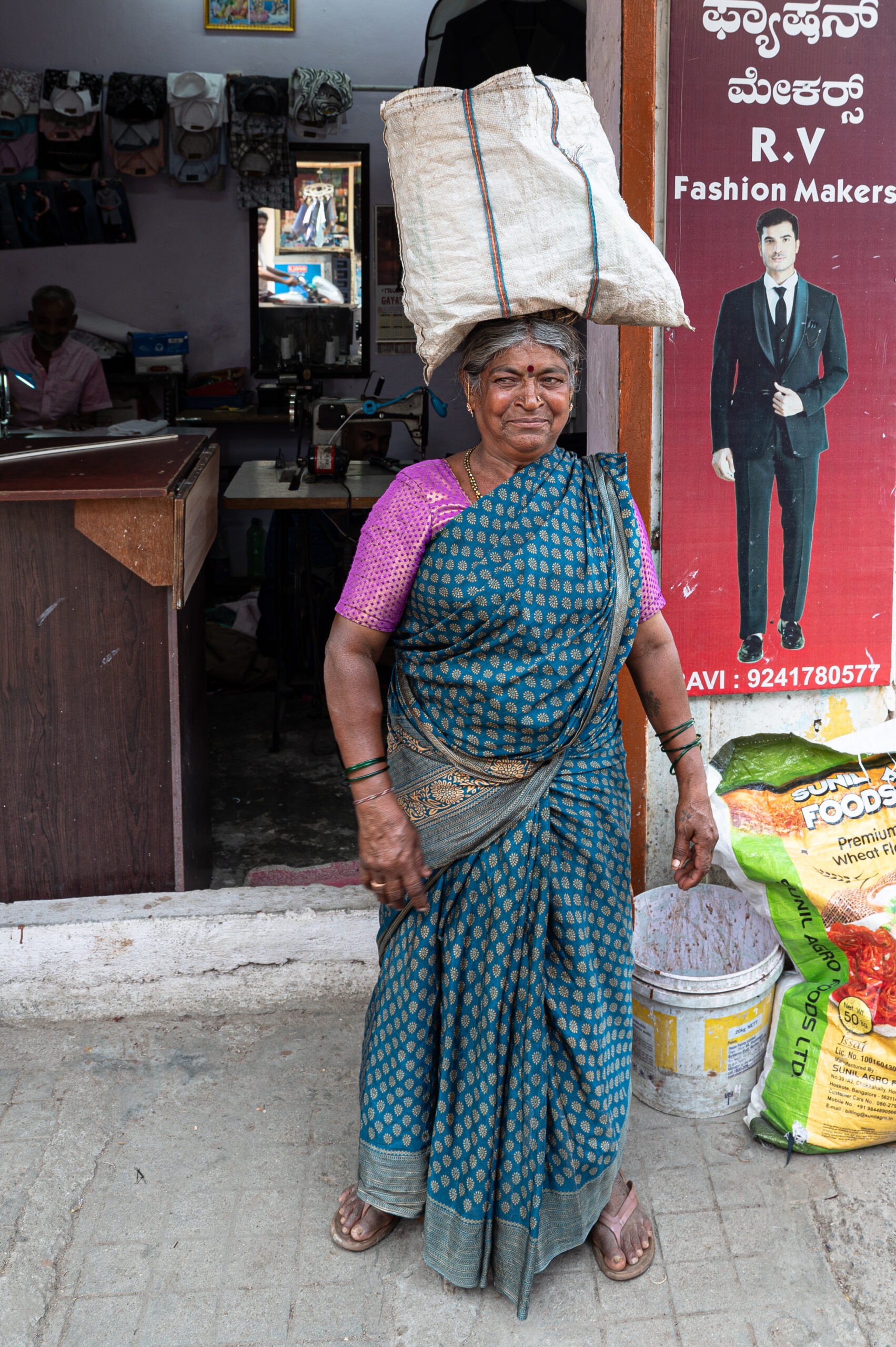 vrouw draagt zak op het hoofd, India